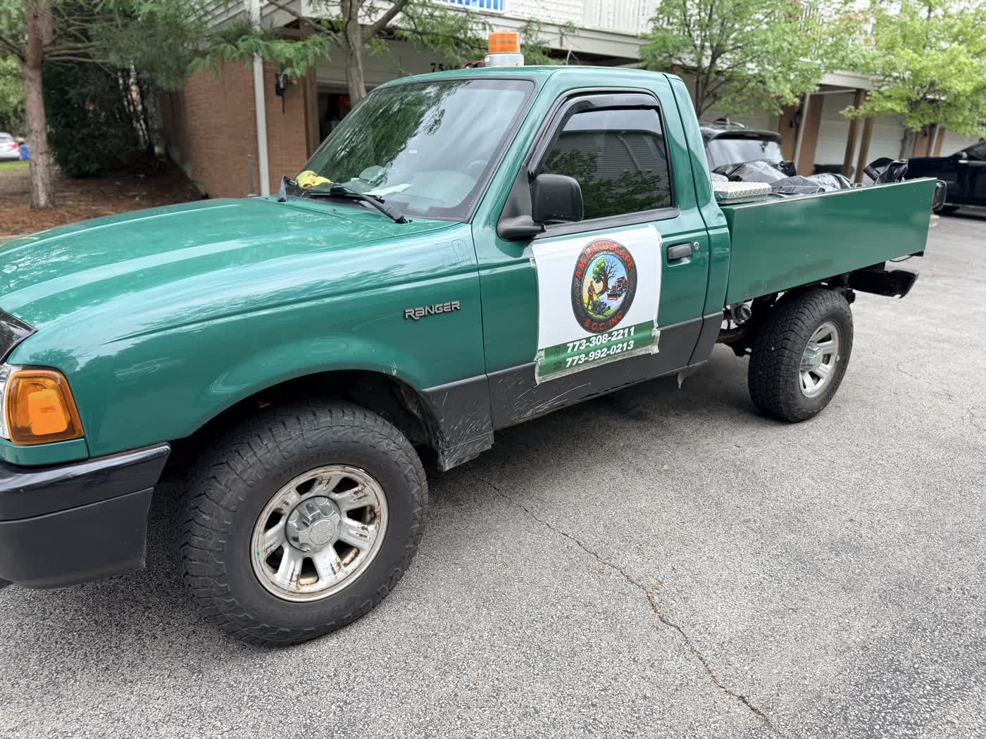 AM Landscape's green truck parked on a Chicago street